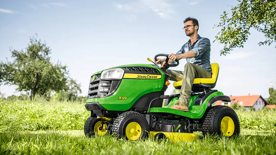 homen em cima de trator de jardim x126 John Deere